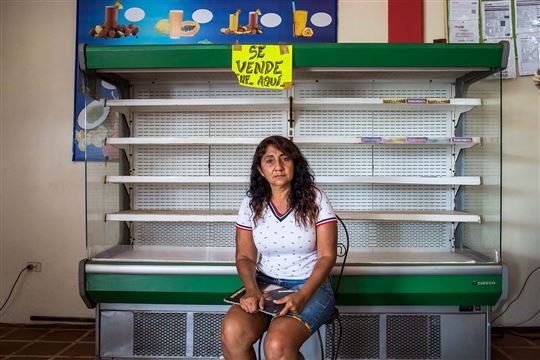 Dona Selva Mapunqui, em frente às prateleiras vazias de um comércio local